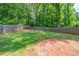 Large, enclosed backyard with a mix of grassy areas and a wooded perimeter, offering privacy and space at 1171 Bailing Dr, Lawrenceville, GA 30043