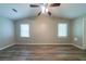 An empty bedroom with a ceiling fan, two windows, and neutral paint at 1171 Bailing Dr, Lawrenceville, GA 30043