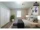 This staged bedroom features a plant, two side tables, modern lighting, and large white double-door closet at 1171 Bailing Dr, Lawrenceville, GA 30043