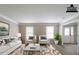 This staged living room features a white couch, two white armchairs, a rug and two windows at 1171 Bailing Dr, Lawrenceville, GA 30043