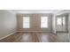 An empty living room featuring fresh paint, flooring, and two windows at 1171 Bailing Dr, Lawrenceville, GA 30043