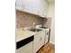 This kitchen features a gas range, tile backsplash and white cabinets at 2805 Ne Ne Expressway Ne # B-26, Atlanta, GA 30345