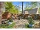 Backyard with a stone patio featuring a fire pit, mature landscaping, and outdoor seating at 2898 Stockbridge Way, Dacula, GA 30019