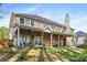 Backyard featuring a large back porch, a lush green lawn, and mature landscaping at 2898 Stockbridge Way, Dacula, GA 30019
