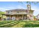 Backyard featuring a large back porch, a lush green lawn, and mature landscaping at 2898 Stockbridge Way, Dacula, GA 30019