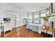 Well-lit bedroom with hardwood floors, bay window, and white brick accent wall at 2898 Stockbridge Way, Dacula, GA 30019