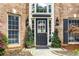 Elegant front door with glass panels, flanked by potted plants and stylish exterior lighting at 2898 Stockbridge Way, Dacula, GA 30019