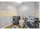 Functional laundry room with modern washer and dryer, laundry basket, and patterned floor mat at 2898 Stockbridge Way, Dacula, GA 30019