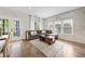 A comfortable living room features a gray couch, and windows with natural light at 2898 Stockbridge Way, Dacula, GA 30019
