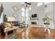 Open living room featuring a fireplace, hardwood floors, and tall windows to bring in natural light at 2898 Stockbridge Way, Dacula, GA 30019