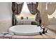 Elegant bathroom features a soaking tub, separate shower, and beautiful tile work at 15 Granville Ln, Covington, GA 30016