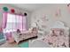 Charming bedroom featuring twin beds, colorful decor, and natural light from the window at 15 Granville Ln, Covington, GA 30016