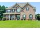Traditional brick two-story home with a well-manicured lawn and a welcoming front porch with white columns at 15 Granville Ln, Covington, GA 30016