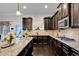 Modern kitchen design featuring dark wood cabinets, granite countertops, and stainless-steel appliances at 15 Granville Ln, Covington, GA 30016