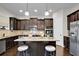 Well-equipped eat-in kitchen island features stainless appliances, granite counters, and dark cabinetry at 15 Granville Ln, Covington, GA 30016