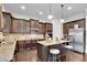 Eat-in kitchen island features dark wood cabinets, granite counters, stainless appliances, and breakfast bar at 15 Granville Ln, Covington, GA 30016