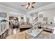 Bright living room featuring hardwood floors, a ceiling fan, and a seamless flow into the kitchen at 15 Granville Ln, Covington, GA 30016