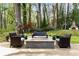 Relaxing backyard oasis featuring a stone fire pit with seating, lush landscaping, and mature trees at 259 Dartmoor Cir, Atlanta, GA 30328