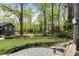 The backyard features a stone patio, wooden chair and manicured lawn at 259 Dartmoor Cir, Atlanta, GA 30328