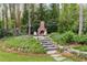 Beautiful brick fireplace and stone patio with seating, surrounded by lush landscaping and mature trees at 259 Dartmoor Cir, Atlanta, GA 30328