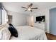 Bright main bedroom featuring a ceiling fan, dresser with TV, and access to the ensuite bathroom at 259 Dartmoor Cir, Atlanta, GA 30328