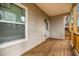 Covered back porch with wood decking, featuring a window, exterior door, and tan siding at 515 Federal Se Ter, Atlanta, GA 30315