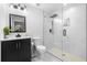 Modern bathroom with black vanity, marble tile shower, and frameless glass enclosure at 770 Waters Sw Dr, Atlanta, GA 30310