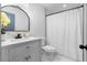 Modern bathroom featuring a gray vanity, white marble tile and a bathtub with white curtain at 770 Waters Sw Dr, Atlanta, GA 30310