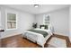 Bright bedroom with hardwood floors, two windows, and a comfortable bed with green accents at 770 Waters Sw Dr, Atlanta, GA 30310