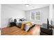 Bright bedroom featuring hardwood floors, two windows, and a comfortable bed with dark accents at 770 Waters Sw Dr, Atlanta, GA 30310