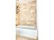 Bright bathroom with a white tub and shower featuring a stone backsplash and tiled floor at 195 14Th Ne St # 1507, Atlanta, GA 30309