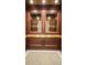 Exquisite wood elevator interior with mirrored panels and brass accents at 195 14Th Ne St # 1507, Atlanta, GA 30309