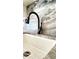 Close-up of kitchen faucet with granite backsplash and white sink at 195 14Th Ne St # 1507, Atlanta, GA 30309