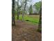 Scenic backyard with mature trees, a small stream, and a bridge at 4620 Oak Grove Cir, Cumming, GA 30028