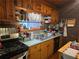 Rustic kitchen with wood cabinets, brick wall and double sink at 4620 Oak Grove Cir, Cumming, GA 30028