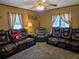 Comfortable living room featuring large, comfortable leather seating and a ceiling fan at 4620 Oak Grove Cir, Cumming, GA 30028