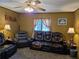 Inviting living room features leather seating, ceiling fan, and warm, welcoming decor at 4620 Oak Grove Cir, Cumming, GA 30028