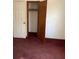Bedroom featuring neutral walls, red carpet, and closet with basic rod shelving at 506 Carlton Dr, Palmetto, GA 30268