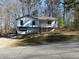 Split-level home with a front-facing garage, a covered front porch, and a yard at 506 Carlton Dr, Palmetto, GA 30268