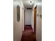 Hallway with neutral walls, red carpet, and doors to rooms at 506 Carlton Dr, Palmetto, GA 30268