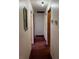 Long hallway with maroon carpet and white walls leads to other rooms in the house at 506 Carlton Dr, Palmetto, GA 30268