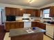 Traditional kitchen with center island, wooden cabinets, and a window above the sink at 506 Carlton Dr, Palmetto, GA 30268