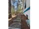 A concrete walkway leads to the rear of the home, surrounded by natural landscaping at 506 Carlton Dr, Palmetto, GA 30268