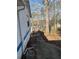 A concrete walkway leads to the rear of the home, surrounded by natural landscaping at 506 Carlton Dr, Palmetto, GA 30268