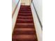 Carpeted stairway with a dark metal handrail with dark wood trim at 506 Carlton Dr, Palmetto, GA 30268