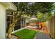 Outdoor deck area with cozy seating under an umbrella, surrounded by lush landscaping at 648 Channing Nw Dr, Atlanta, GA 30318