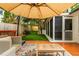 Backyard deck area with comfortable seating under an umbrella, surrounded by greenery at 648 Channing Nw Dr, Atlanta, GA 30318