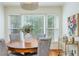 Bright dining area with round table, upholstered chairs, bar cart, and natural light from large windows at 648 Channing Nw Dr, Atlanta, GA 30318