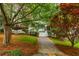 Classic white brick home with manicured lawn, and a tree-lined driveway offering scenic curb appeal at 648 Channing Nw Dr, Atlanta, GA 30318