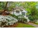 Quaint white brick house with lush landscaping and a charming front yard blooming with spring flowers at 648 Channing Nw Dr, Atlanta, GA 30318